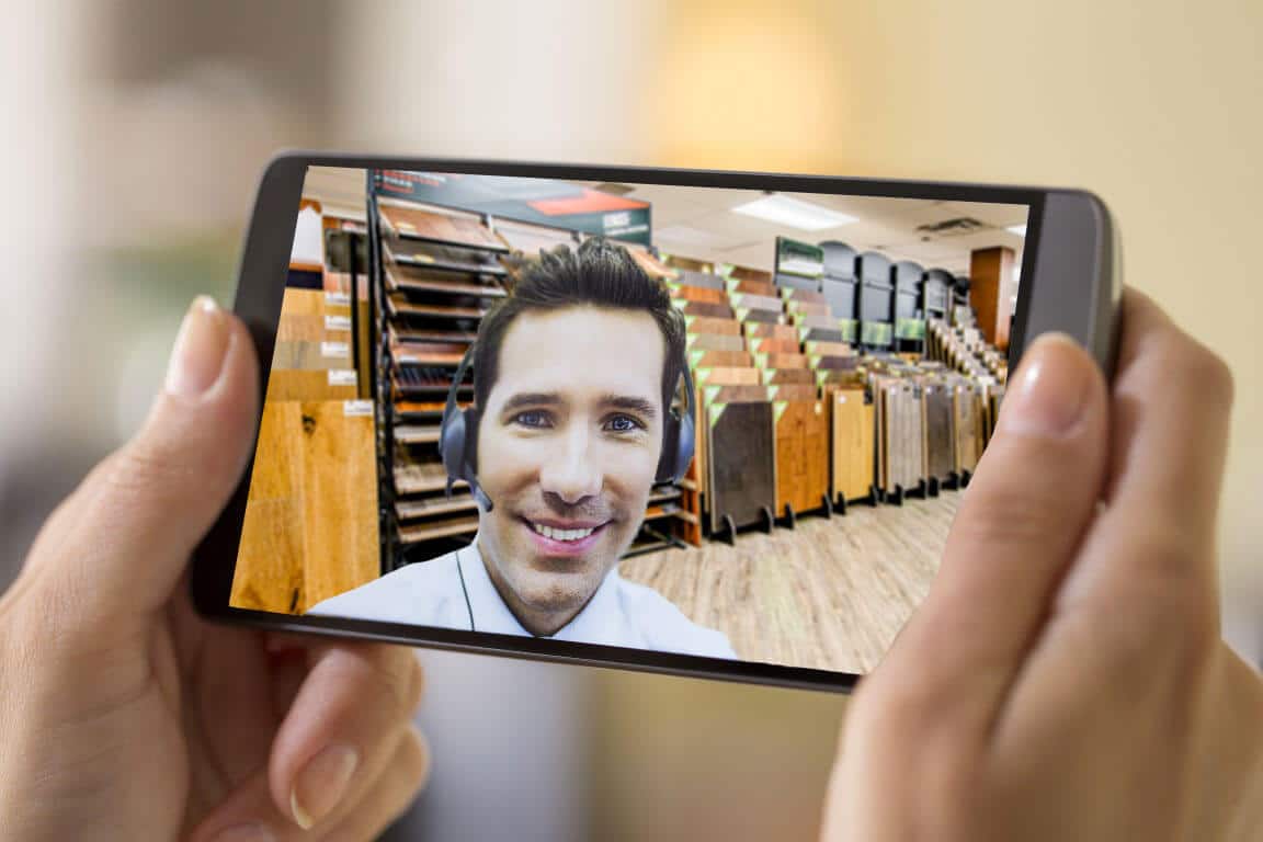 Image depicts person using a mobile phone to shop for floors via video call.