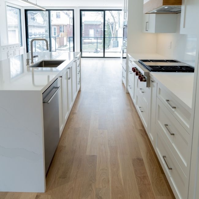 Image depicts a kitchen with ask hardwood floors.