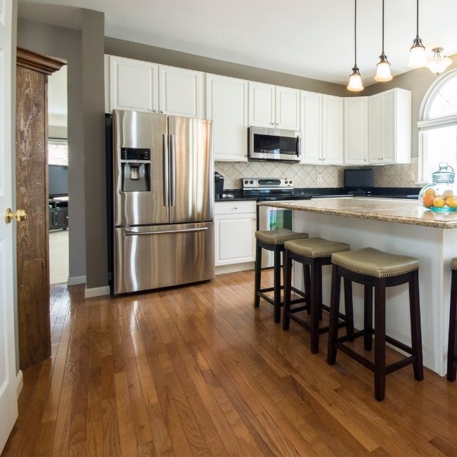 Image depicts a kitchen in a Montreal home with new hardwood floors.\