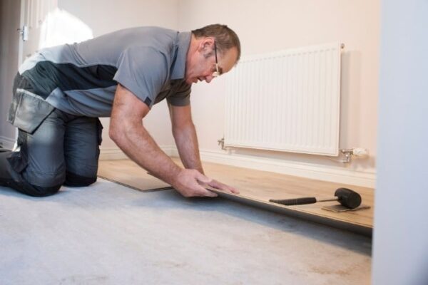 Image depicts a flooring expert installing floors in a Brampton home.