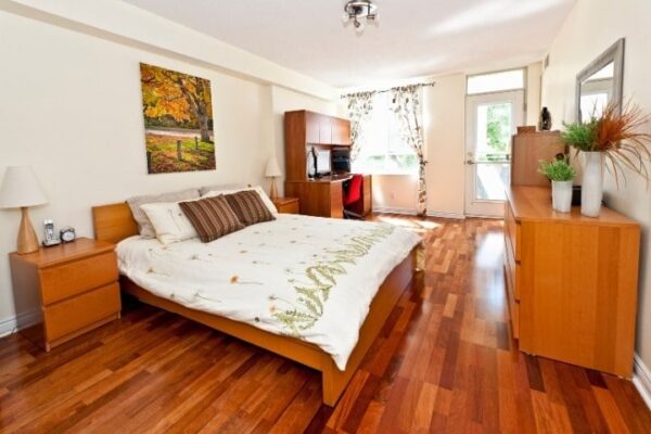 Image depicts a bedroom with new hardwood floors.
