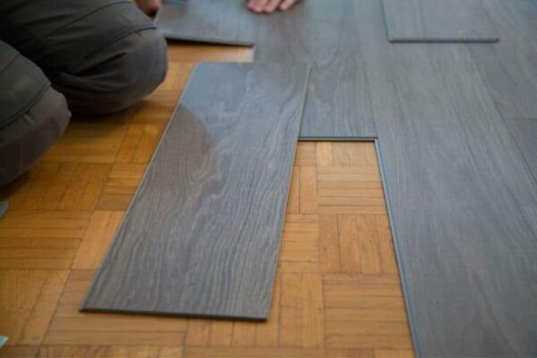 Image depicts a flooring expert installing vinyl floors in a Brampton home.