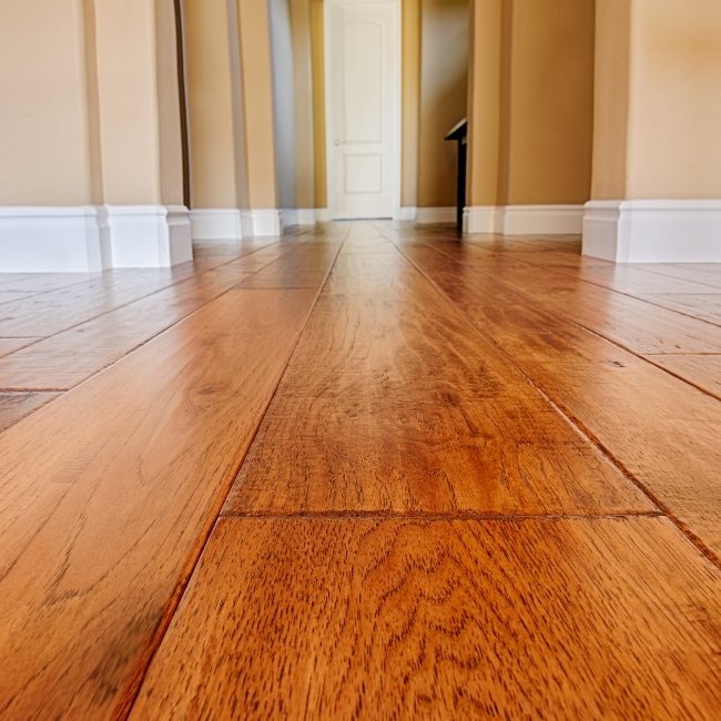 Image depicts a close up of red oak hardwood floors in a living room.