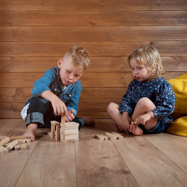 Image depicts two kids playing on silver maple hardwood floors.