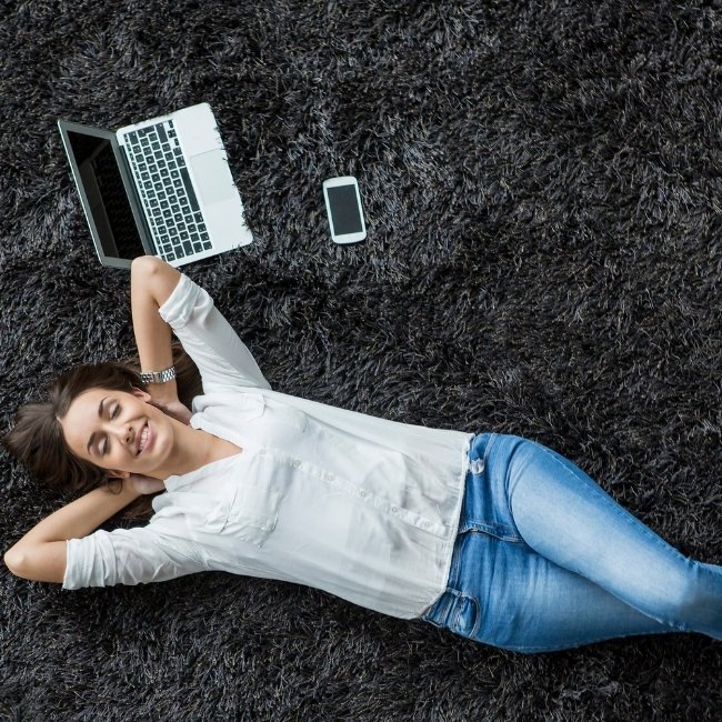 Image depicts a woman laying on a carpet in her London, Ontario home.