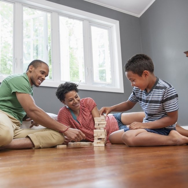 Image depicts a family sitting on hardwood floors in theri Brampton home.