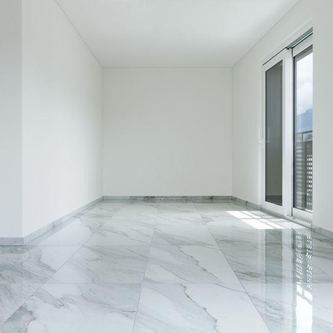 Image depicts the interior of a condo with newly installed white tile floors.