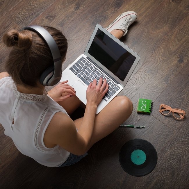 Image depicts a woman sitting on vinyl floors in her London home.
