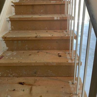 Image depicts old stairs from a laminate and carpet flooring installation project in Toronto, Ontario.