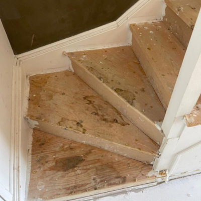 Image depicts old stairs from a laminate and carpet flooring installation project in Toronto, Ontario.